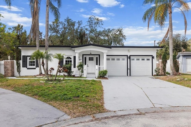 ranch-style home with a garage and a front lawn