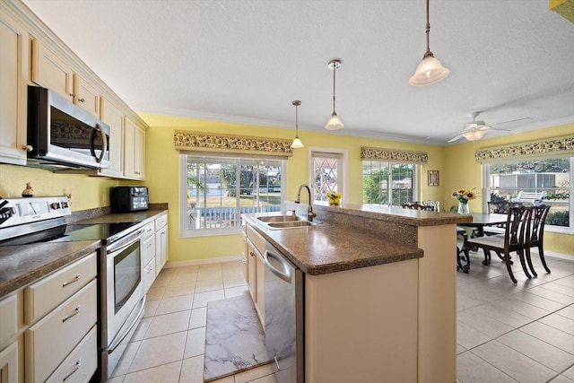 kitchen with appliances with stainless steel finishes, decorative light fixtures, an island with sink, sink, and light tile patterned floors