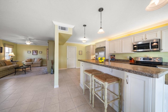 kitchen featuring pendant lighting, a breakfast bar area, white cabinets, and appliances with stainless steel finishes