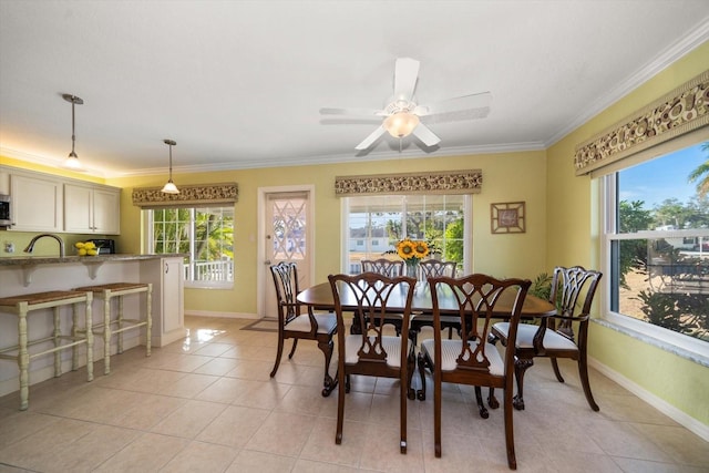 tiled dining area featuring ornamental molding, sink, and ceiling fan