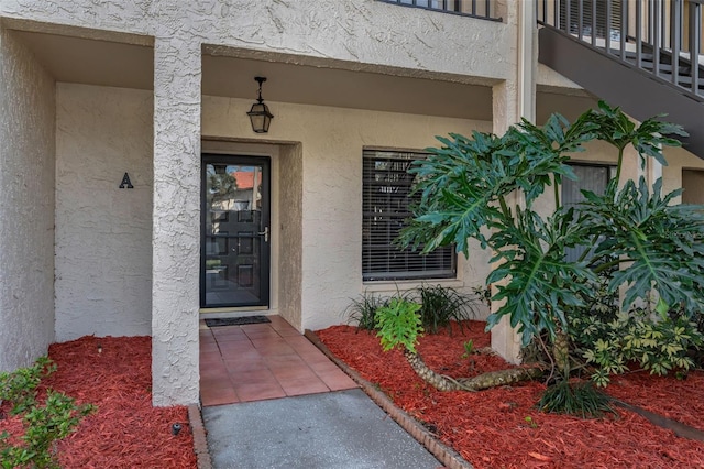 doorway to property featuring a balcony and stucco siding