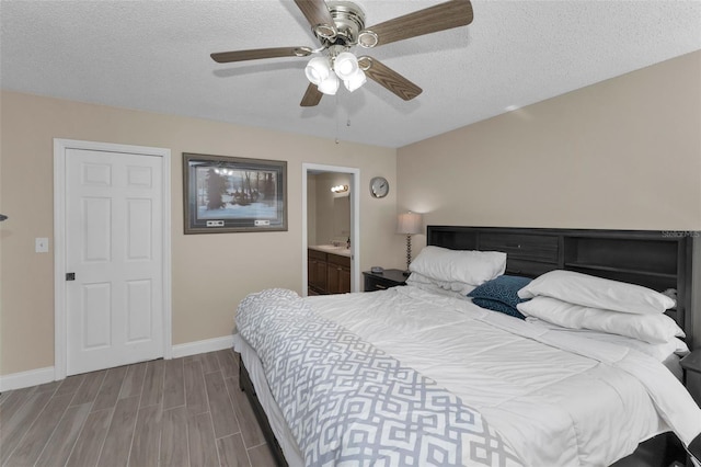 bedroom featuring connected bathroom, ceiling fan, a textured ceiling, wood finished floors, and baseboards