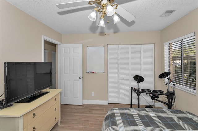 bedroom with ceiling fan, a closet, and a textured ceiling