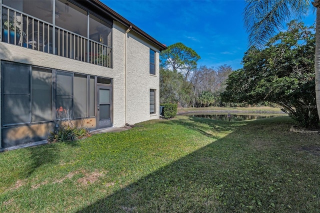 view of yard featuring ceiling fan and a water view