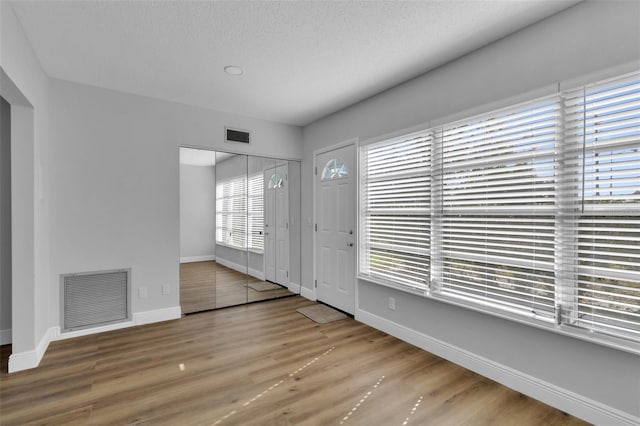 entryway featuring hardwood / wood-style flooring and a textured ceiling