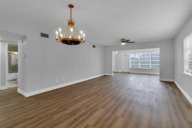 empty room with ceiling fan with notable chandelier and dark hardwood / wood-style floors