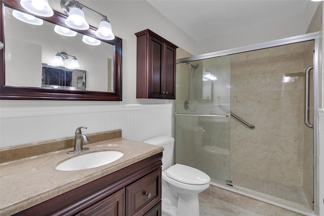 bathroom featuring vanity, toilet, and a shower with shower door