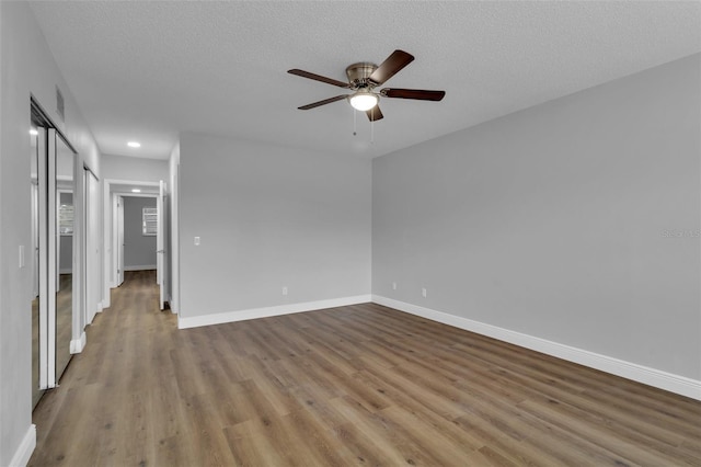 spare room featuring ceiling fan, a textured ceiling, and light hardwood / wood-style flooring