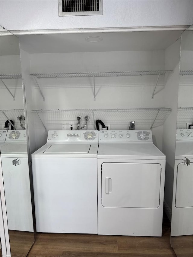 clothes washing area featuring separate washer and dryer and dark hardwood / wood-style floors