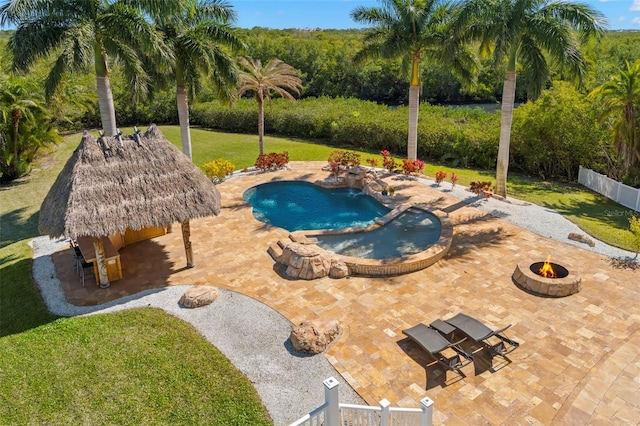 view of pool featuring a yard, an outdoor bar, a patio, an outdoor fire pit, and a gazebo