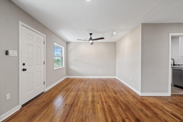 foyer entrance with ceiling fan, sink, and hardwood / wood-style floors