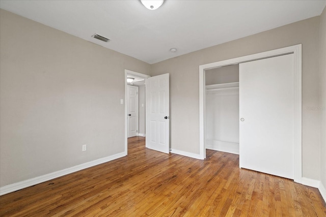 unfurnished bedroom featuring a closet and light wood-type flooring