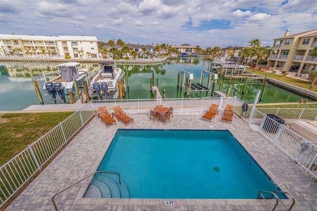 view of pool featuring a water view and a dock