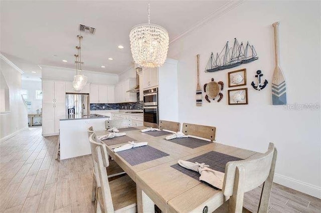 dining room with crown molding, light hardwood / wood-style floors, and a notable chandelier