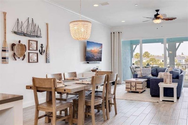 dining space featuring ornamental molding, ceiling fan with notable chandelier, and light hardwood / wood-style flooring