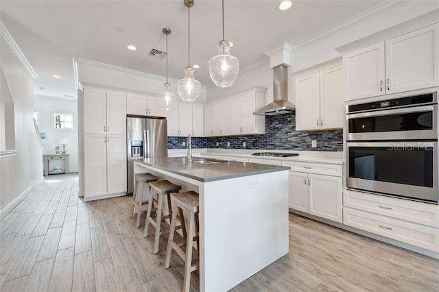 kitchen featuring white cabinetry, appliances with stainless steel finishes, sink, and wall chimney exhaust hood