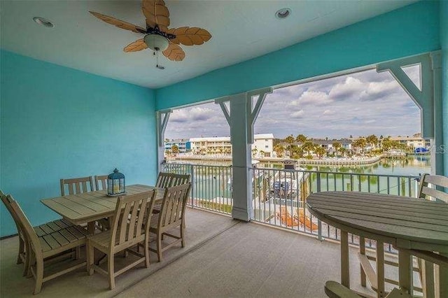 exterior space with ceiling fan and a water view