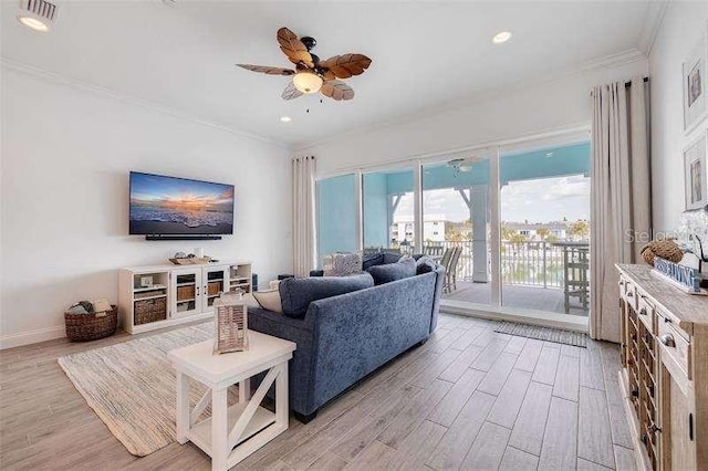 living area with crown molding, light wood-style flooring, recessed lighting, and a ceiling fan