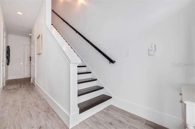 staircase with baseboards and wood tiled floor