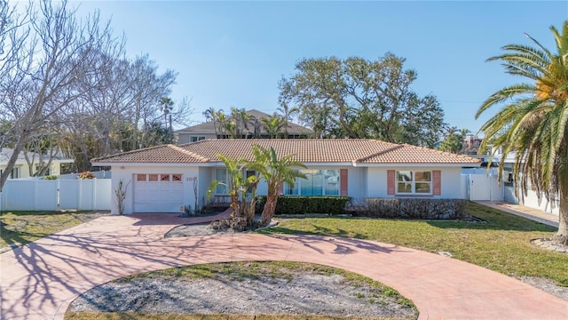 mediterranean / spanish-style house with a garage and a front lawn