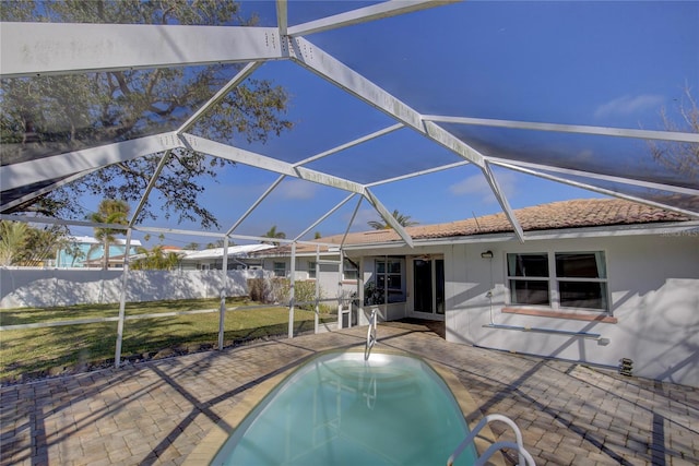 view of swimming pool with glass enclosure and a patio area