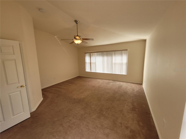 carpeted spare room featuring ceiling fan and vaulted ceiling