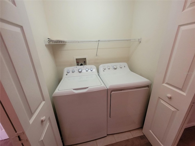 laundry room featuring light tile patterned floors and washing machine and dryer