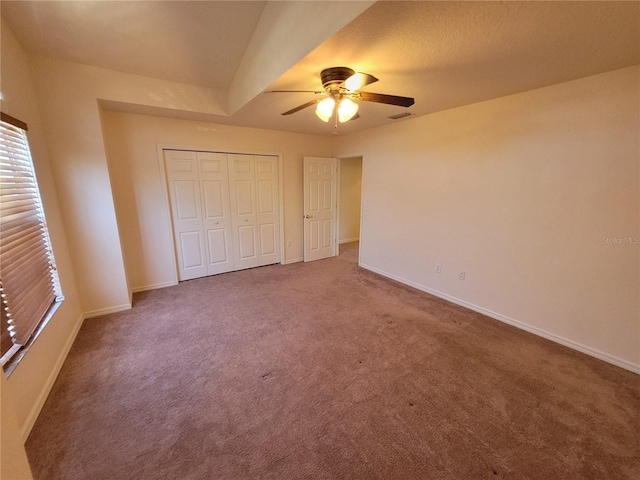 unfurnished bedroom featuring carpet flooring, ceiling fan, and a closet