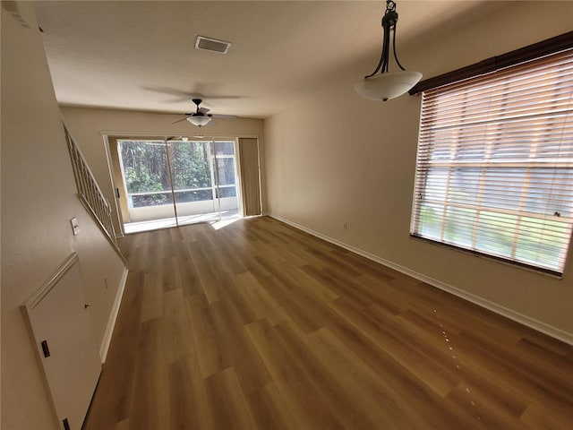 empty room featuring dark wood-type flooring and ceiling fan