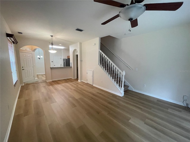 unfurnished living room featuring hardwood / wood-style flooring and ceiling fan