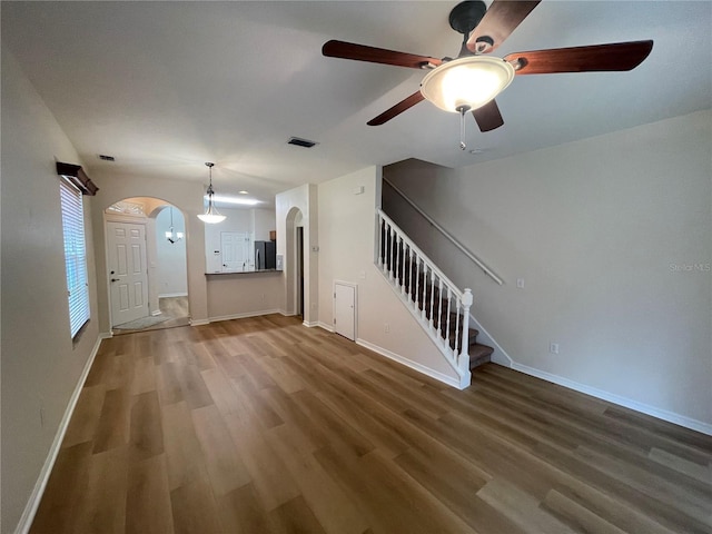 unfurnished living room featuring ceiling fan and dark hardwood / wood-style floors