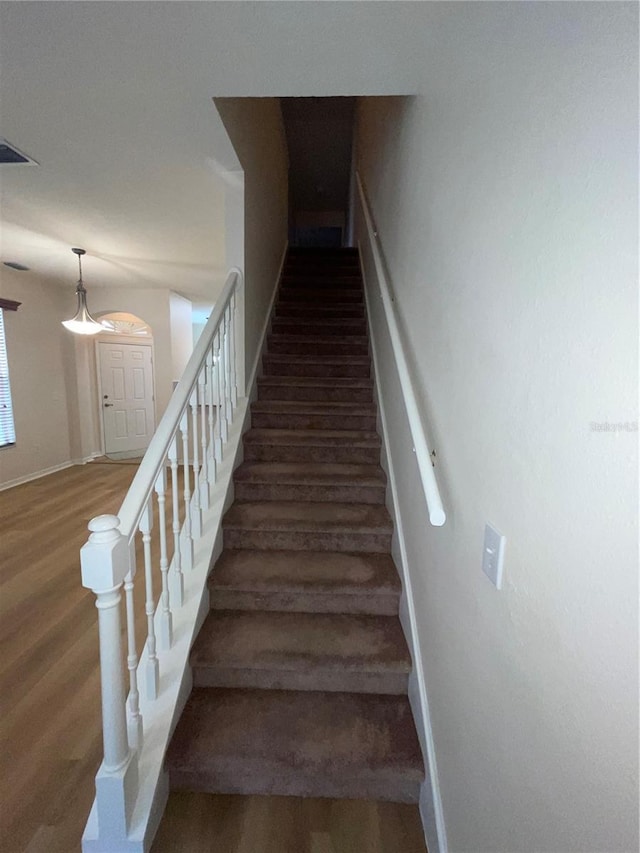 staircase with hardwood / wood-style flooring