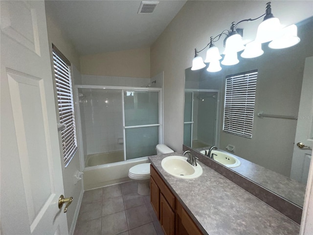 full bathroom with lofted ceiling, toilet, combined bath / shower with glass door, vanity, and tile patterned flooring