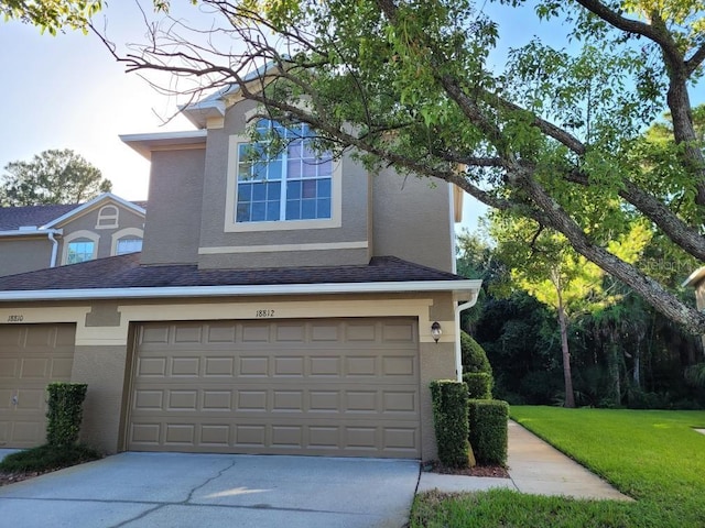 view of property exterior with a garage and a lawn