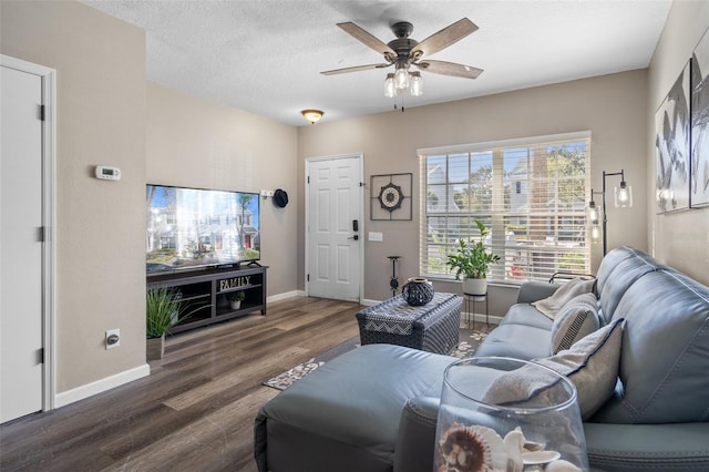 living room with ceiling fan, a textured ceiling, and dark hardwood / wood-style flooring