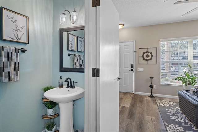 bathroom featuring wood-type flooring and a textured ceiling