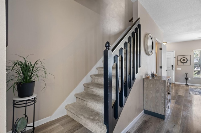 stairway featuring hardwood / wood-style floors and a textured ceiling