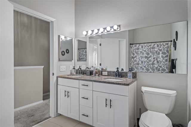 bathroom featuring vanity, toilet, and tile patterned flooring