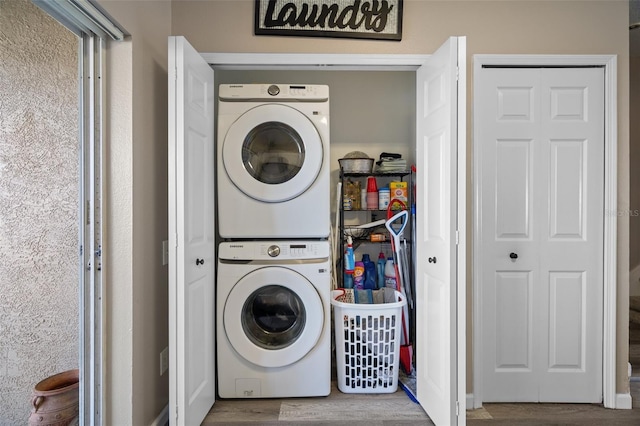 laundry area with stacked washer and dryer and wood-type flooring