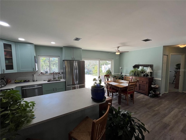 kitchen featuring sink, tasteful backsplash, appliances with stainless steel finishes, dark hardwood / wood-style floors, and ceiling fan