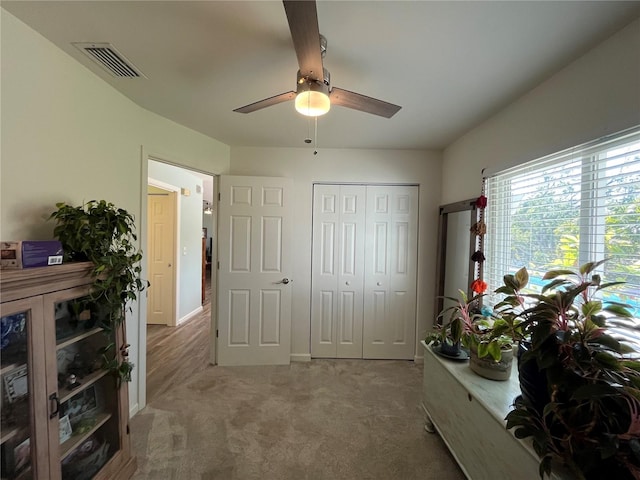 interior space with carpet floors, ceiling fan, and a closet