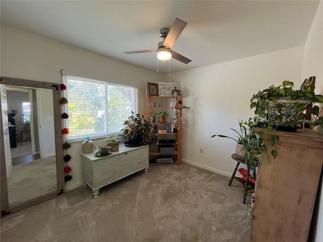 sitting room featuring light colored carpet and ceiling fan