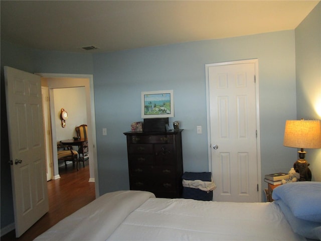 bedroom with dark wood-type flooring