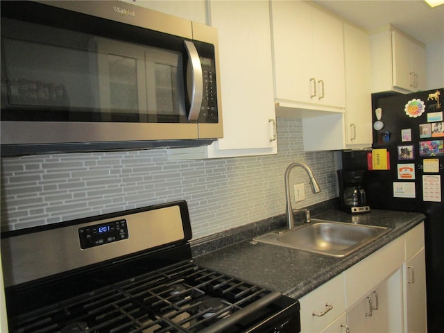 kitchen with white cabinetry, appliances with stainless steel finishes, sink, and backsplash