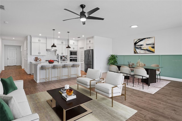 living room featuring wood-type flooring and ceiling fan