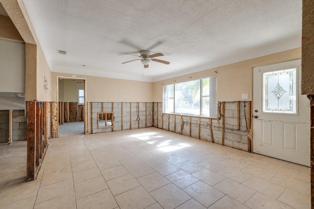 entrance foyer featuring ceiling fan and a textured ceiling