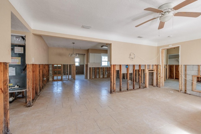 empty room with heating unit, a textured ceiling, and ceiling fan