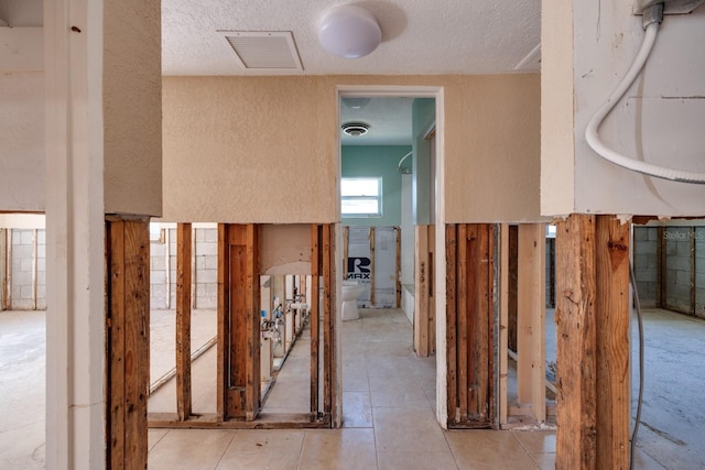 hall featuring a textured ceiling