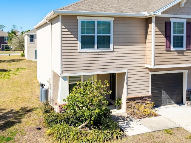 view of property exterior with a garage and a lawn