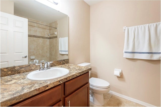 bathroom featuring vanity, toilet, tile patterned flooring, and a tile shower